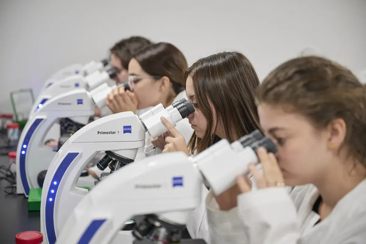 Alumna viendo en el microscopio.