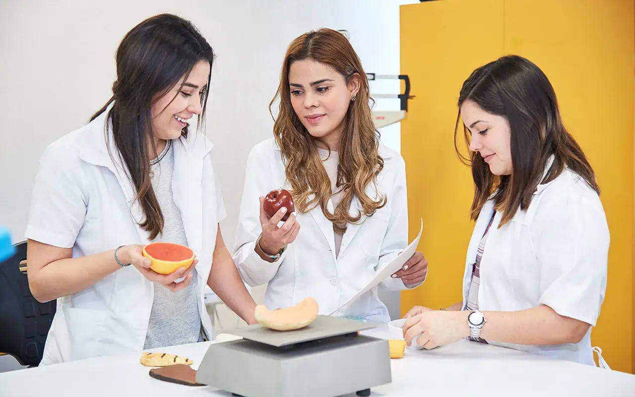 Alumnas interactuando con alimentos.