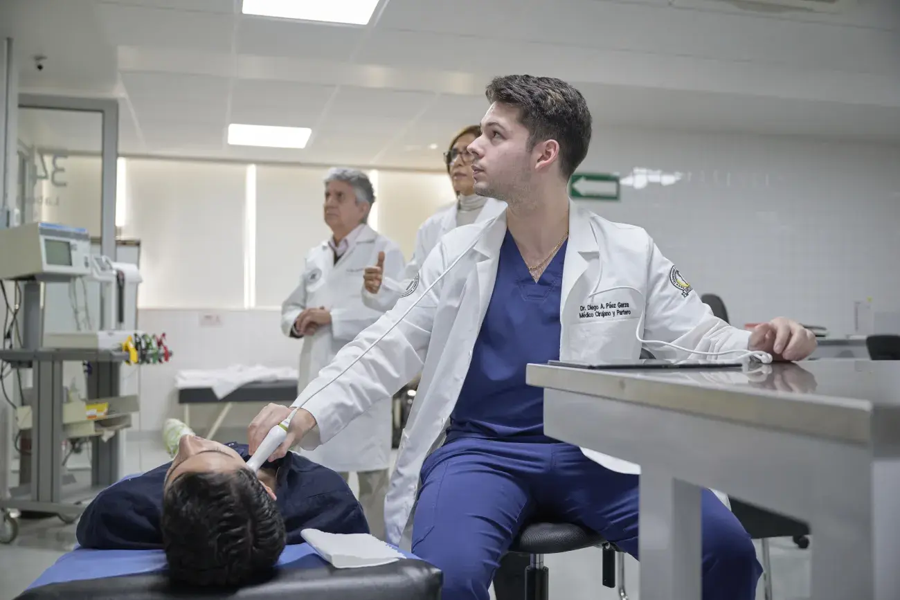 Alumna con estetoscopio revisando al paciente.